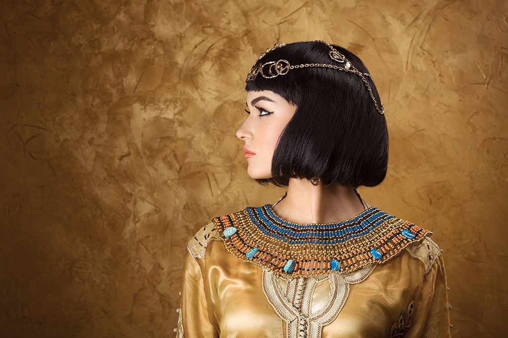 Ancient Egyptian jewelry with intricate beadwork and gold accents worn by a person in traditional attire.